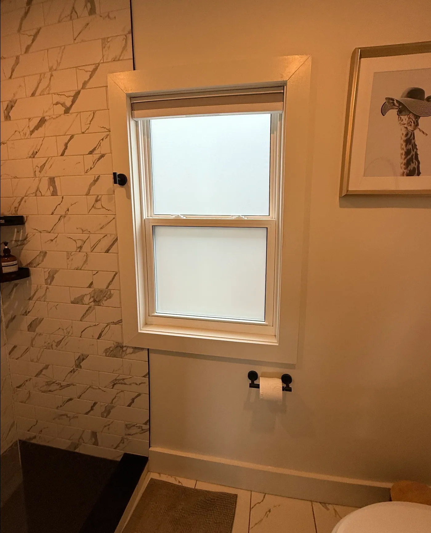 The same bathroom window after privacy film: the glass reads as a soft frosted finish for daytime privacy, while daylight still passes through.